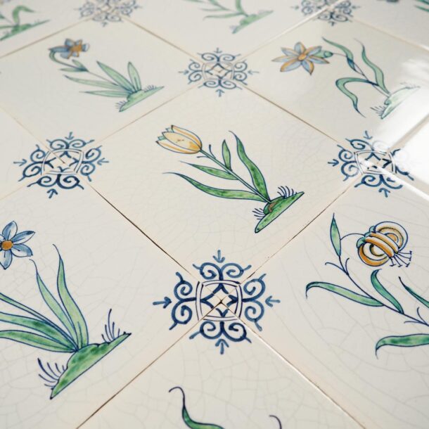 Hand-painted Delft tiles with flowers in polychrome decorated with ox-head corner motif