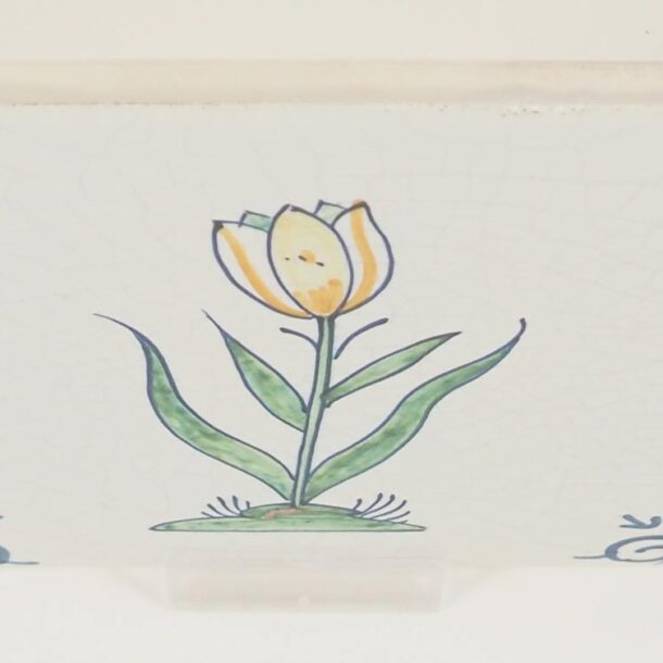 Hand-painted Delft tiles with flowers in polychrome decorated with ox-head corner motif